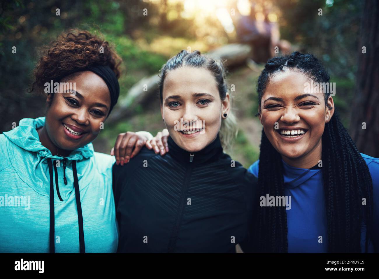 Hacemos cambios positivos en nuestro cuerpo. Retrato de mujeres jóvenes deportivas trabajando en el bosque. Foto de stock