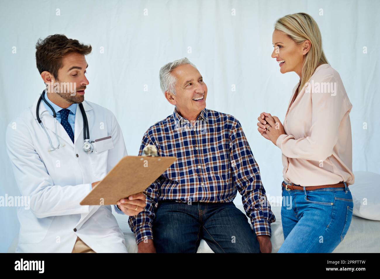 Nada más que buenas noticias hoy. Un médico que comparte los resultados positivos de una prueba con un paciente en su consultorio. Foto de stock