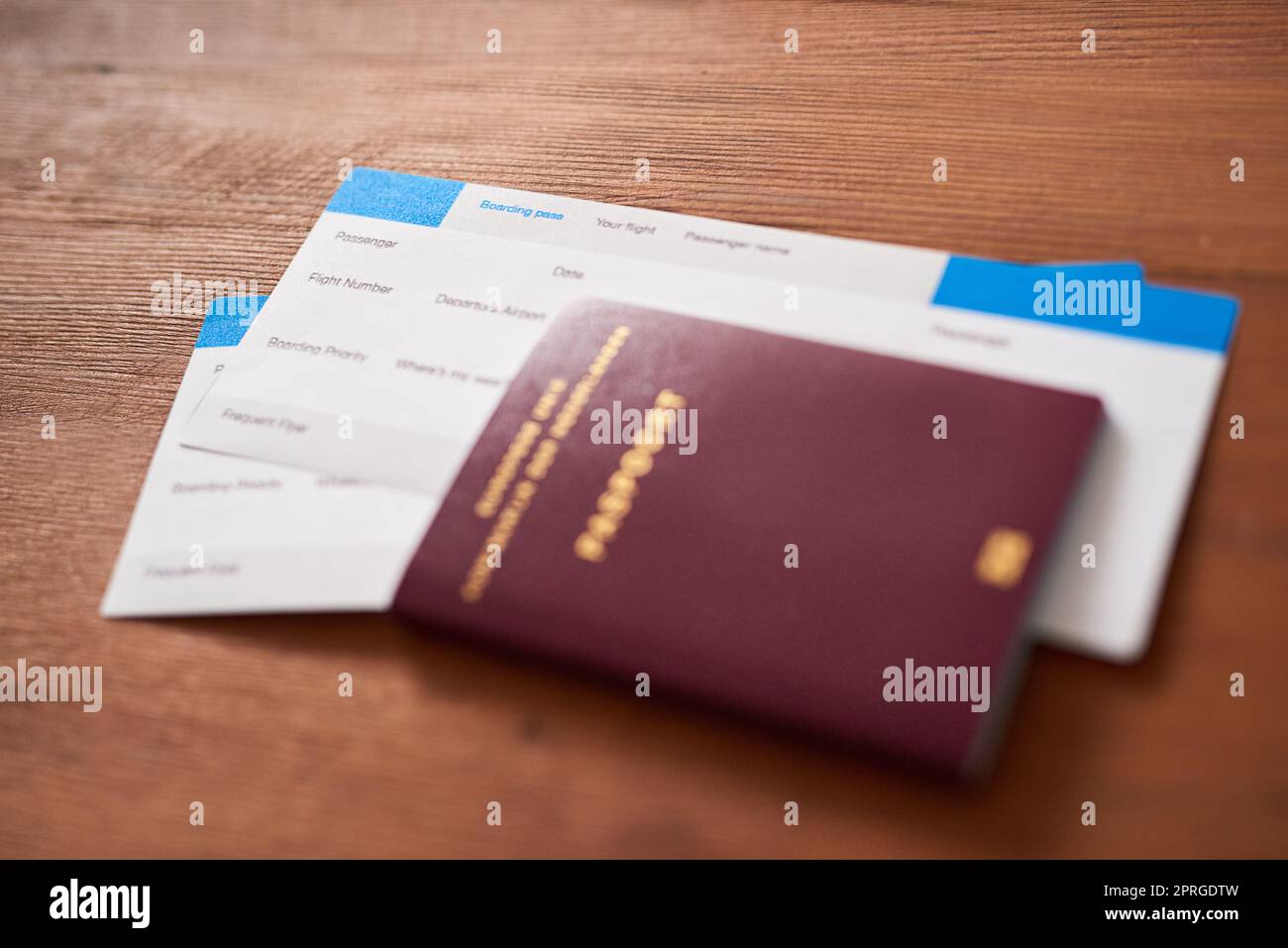No llegaré lejos sin ellos: Dos billetes de avión y un pasaporte en una mesa. Foto de stock