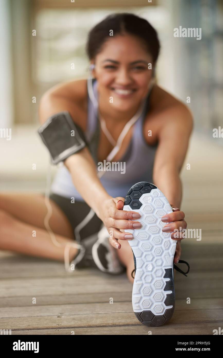 Más forma física equivale a menos fatiga. Retrato de una joven deportiva calentándose antes de correr. Foto de stock