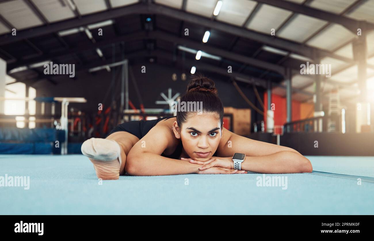 Fuerte atlética mujer negra en un gimnasio, lista y concentrada de rodillas  para hacer deporte, vestida con ropa deportiva roja