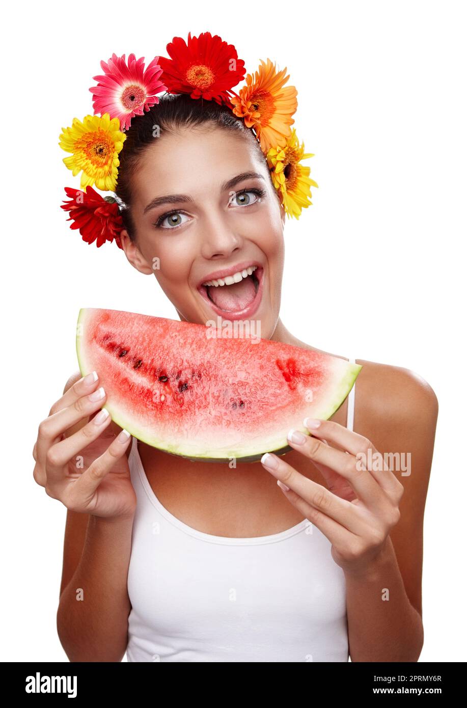 Feliz de comer de forma saludable. Retrato recortado de una hermosa joven que llevaba una corona de flores y comiendo una sandía. Foto de stock