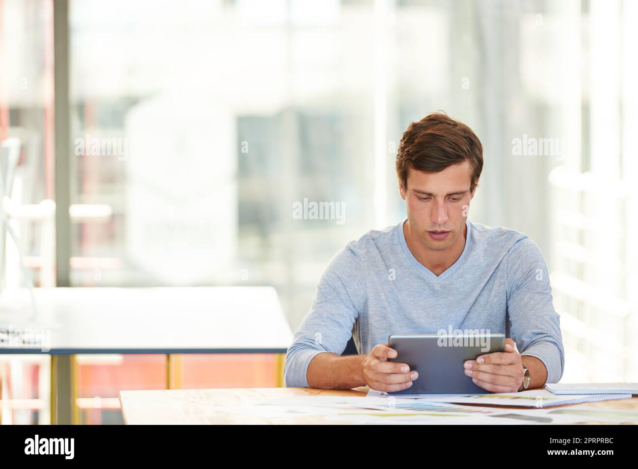 Comprobación de las últimas aplicaciones de diseño. Un diseñador que utiliza una tableta digital mientras trabaja en una oficina. Foto de stock