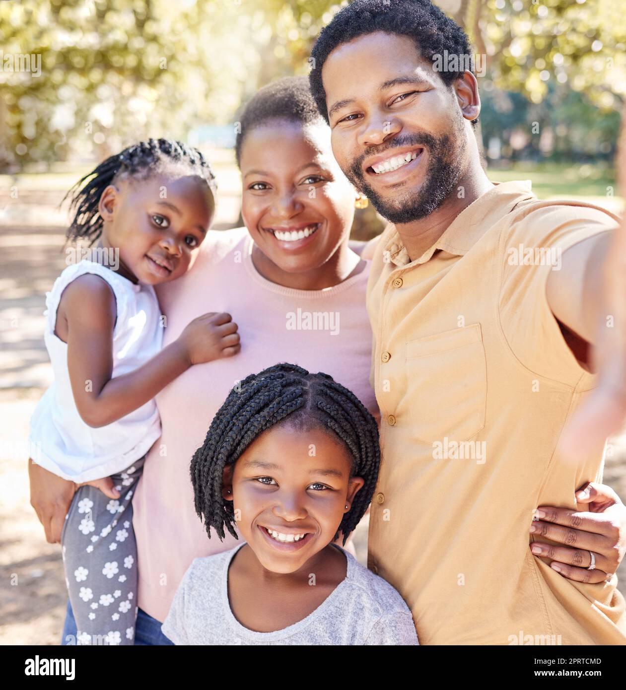 Familia negra feliz tomar un selfie en la naturaleza en un viaje de vacaciones juntos disfrutar de tiempo de calidad en un parque infantil. Sonríe, felicidad y a las chicas africanas les encanta tomar fotos con su madre y su padre Foto de stock