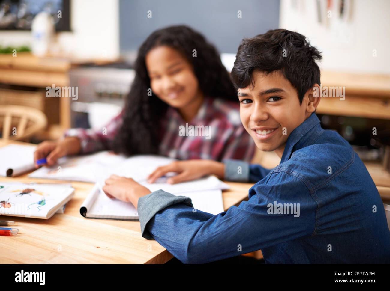 Es mi compañero de estudio favorito. Dos jóvenes estudiantes estudiando juntos en un salón de clase. Foto de stock