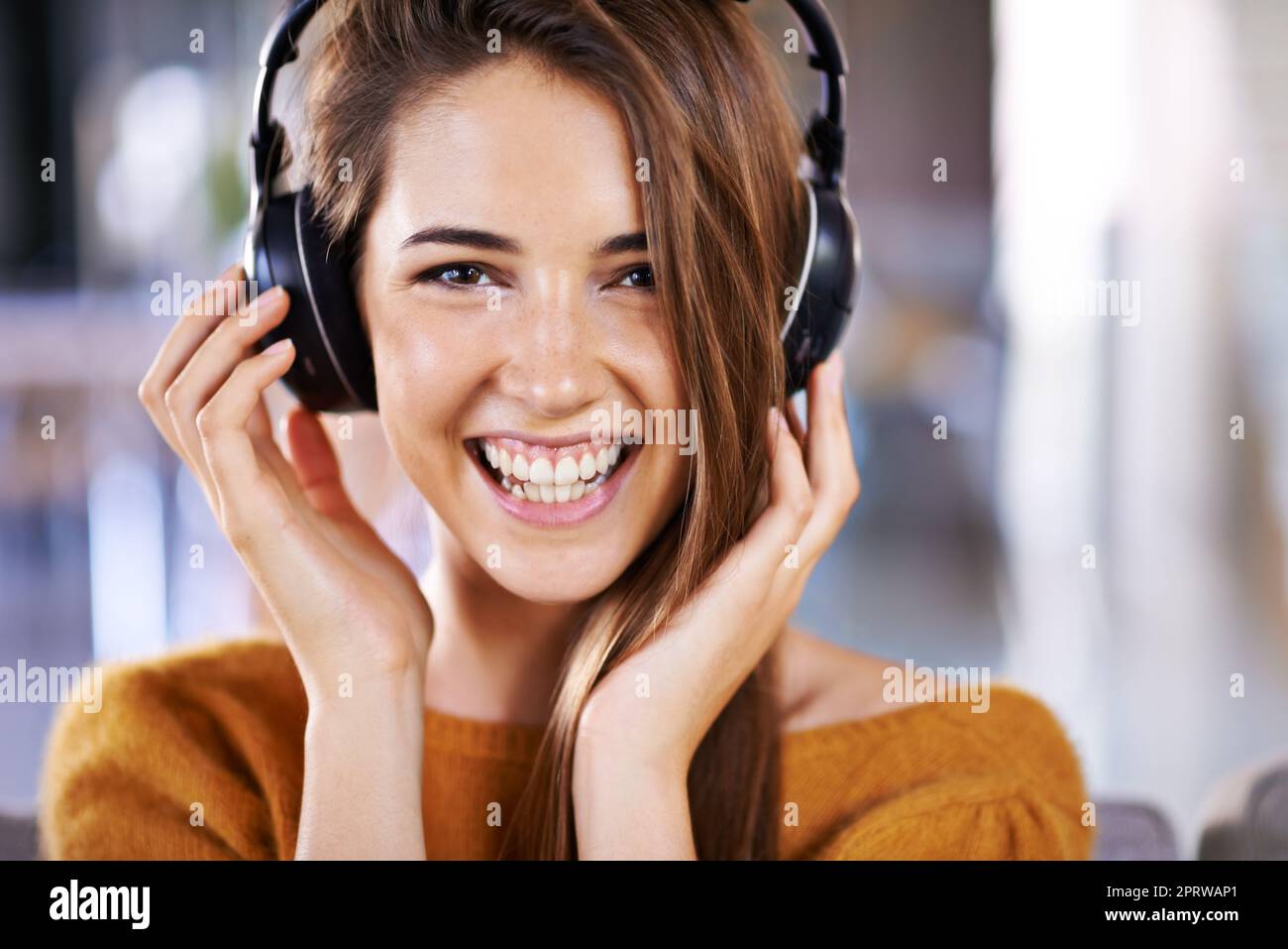 Le encanta su música. Hermosa mujer joven escuchando música en casa. Foto de stock