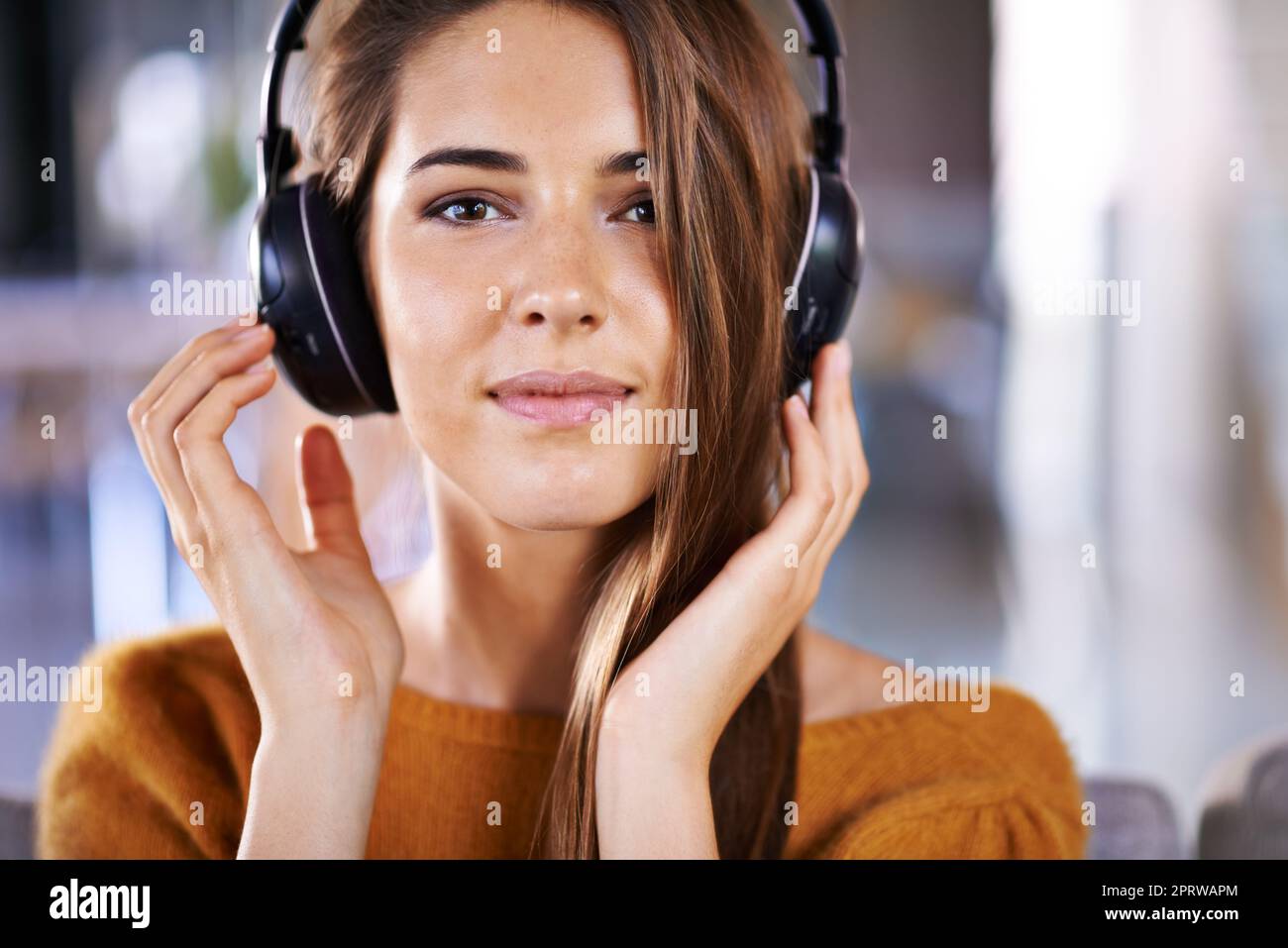 Deja que la música te lleve. Hermosa mujer joven escuchando música en casa. Foto de stock