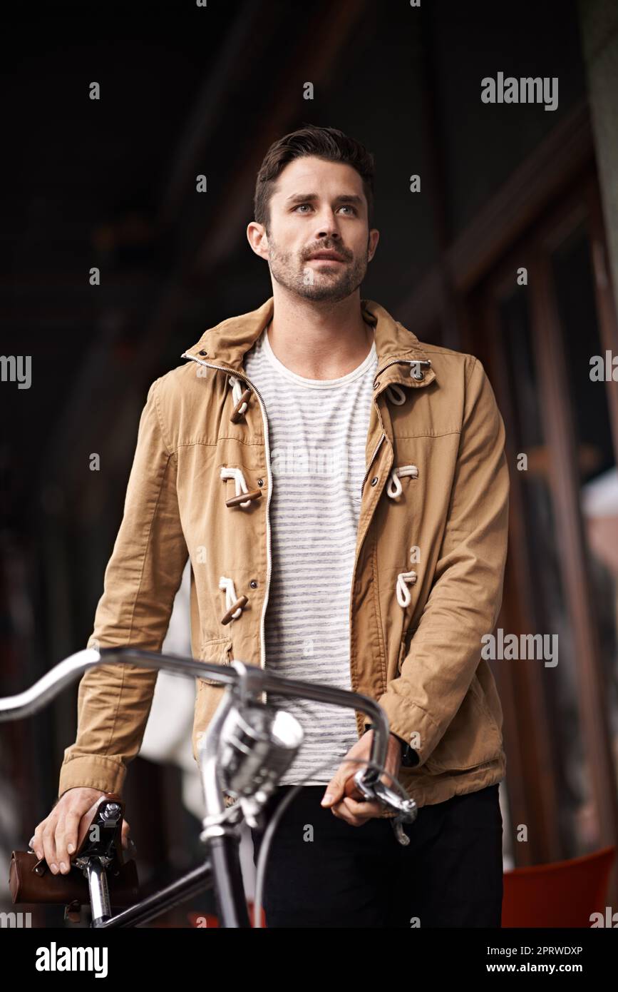 Domingo por la mañana en bicicleta y paseo. Un joven paseando por la ciudad con su bicicleta. Foto de stock