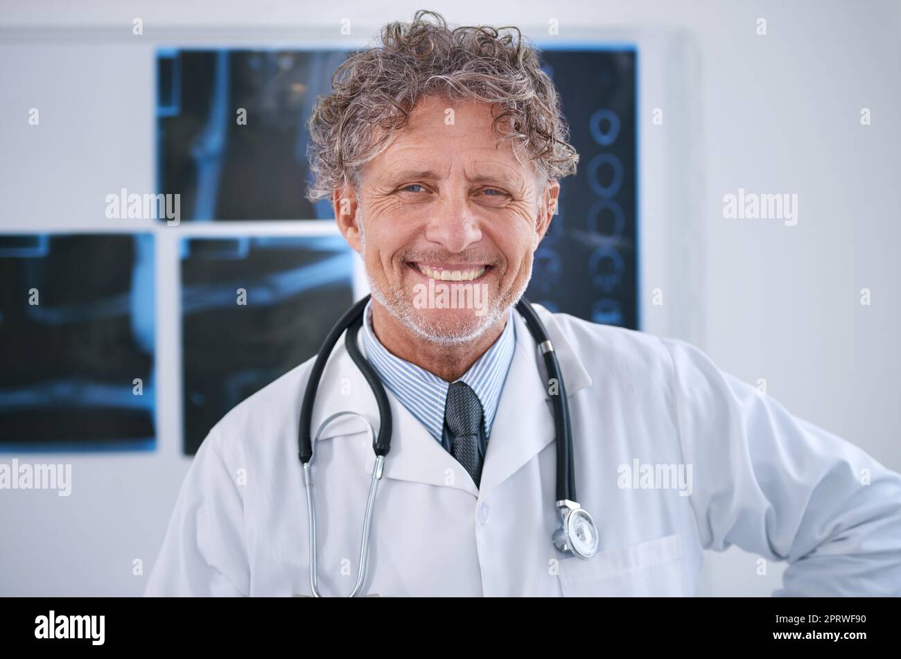 Dedicado a mejorar su calidad de vida. Retrato de un radiólogo maduro sonriente de pie en su oficina. Foto de stock