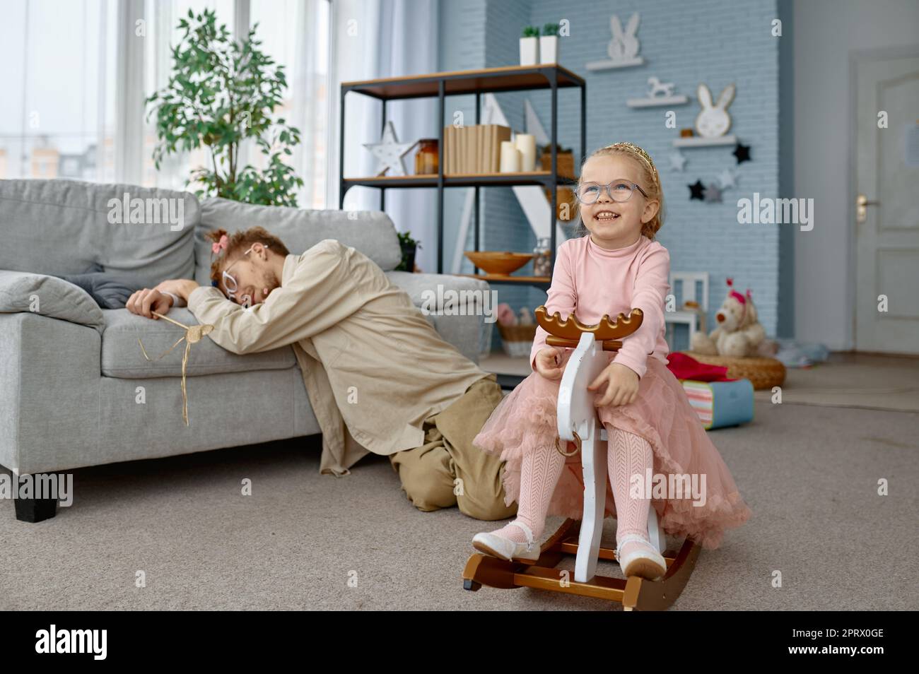 Cansado padre fatiga y niña traviesa Foto de stock