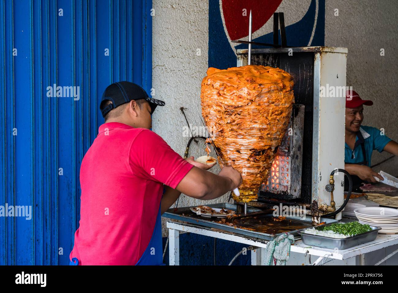 El hombre corta al pastor carne de cerdo a la parrilla de un trompo para un  taco en Tlacolula de Matamoros, Valles Centrales, Oaxaca, México Fotografía  de stock - Alamy