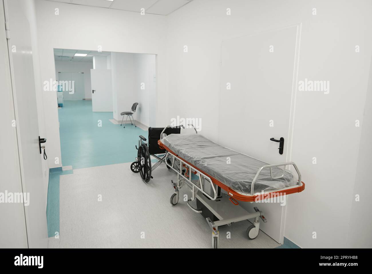 Cama postoperatoria móvil y un soporte para silla de ruedas en el pasillo  del hospital Fotografía de stock - Alamy