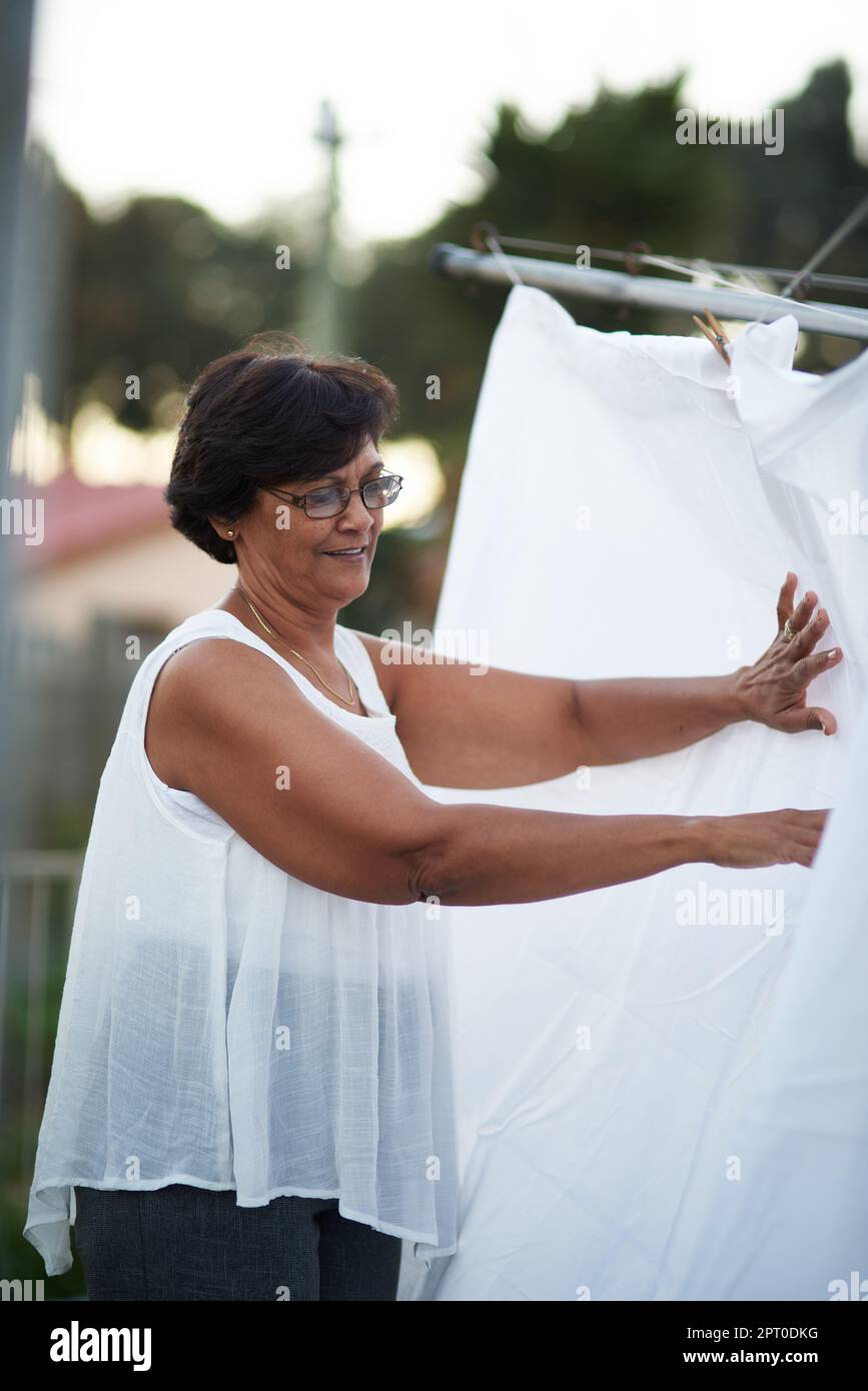 El clima perfecto para lavar la ropa. una mujer madura que cuelga