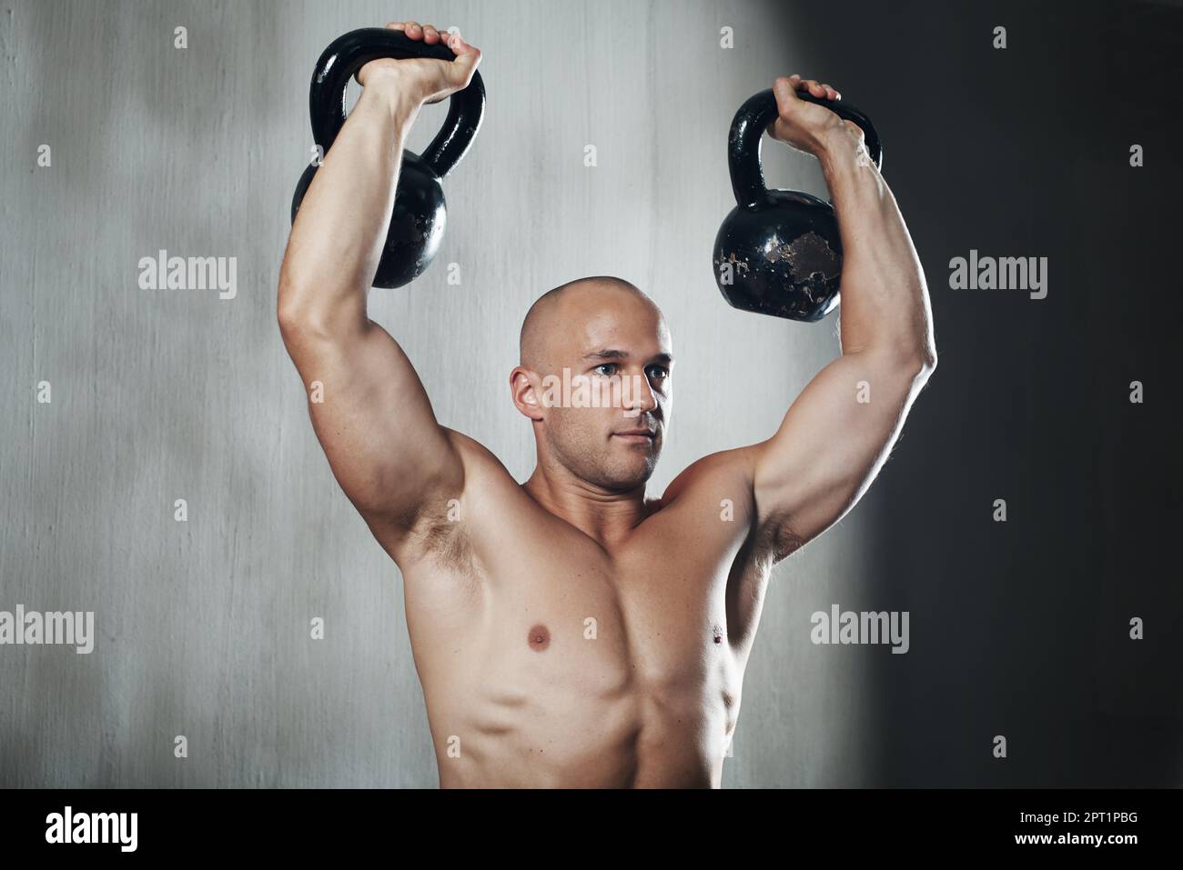 HES para que parezca fácil. un hombre haciendo ejercicio con las campanas  de la tetera en el gimnasio Fotografía de stock - Alamy
