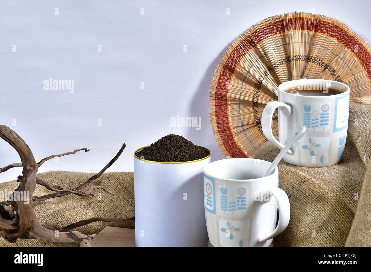 Presente una taza de té negro con hojas de té orgánico fresco en una lata bellamente diseñada - perfecto para publicidad, embalaje Foto de stock