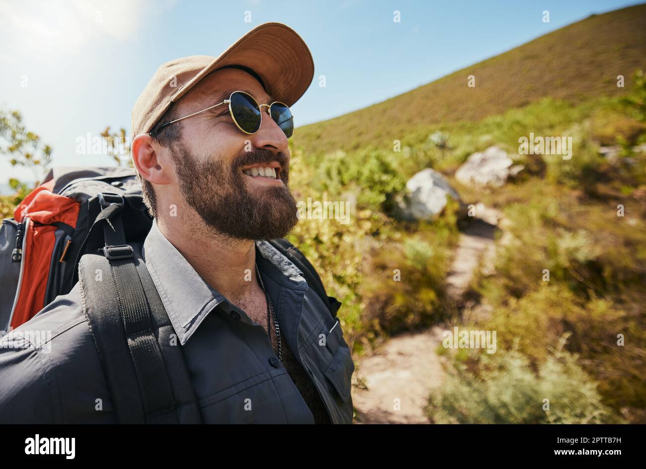 al aventurero con gorro de gafas y una mochila mientras camina o explora por las montañas. Hombre guapo con barba mientras exploraba Fotografía de stock - Alamy