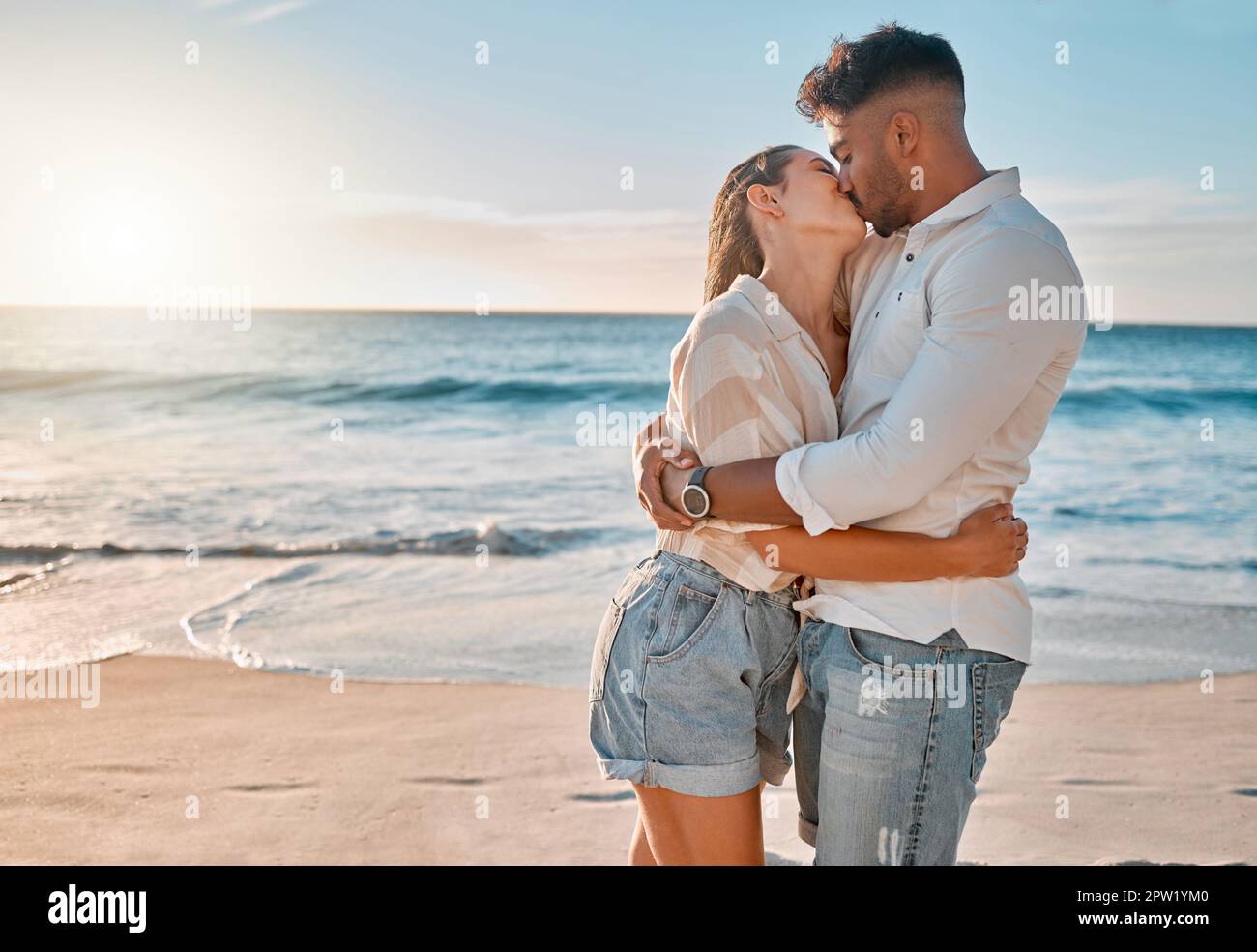 Los días de verano contigo son los mejores. una joven pareja besándose  mientras pasa un día en la playa Fotografía de stock - Alamy