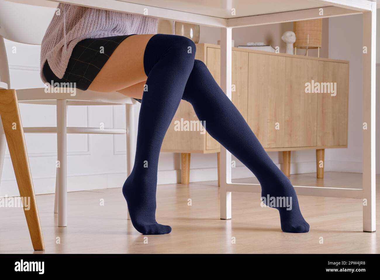 Piernas femeninas en calcetines calientes sobre la rodilla debajo de la  mesa Fotografía de stock - Alamy