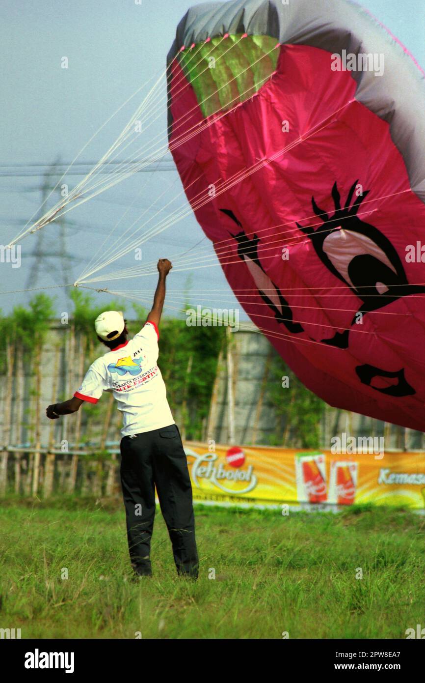 Un participante está volando una cometa en globo durante el 2004° Festival Internacional de Cometas de Yakarta que se celebró el 9-11 de julio en Karnaval (Carnaval) Beach en Ancol Dreamland, North Jakarta, Yakarta, Indonesia. Foto de stock