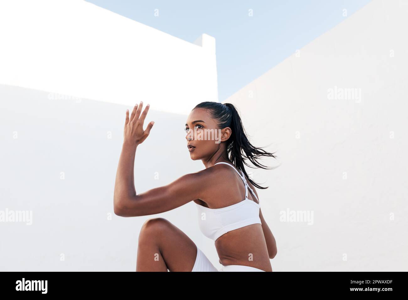 Mujer atleta haciendo un entrenamiento de core. Mujer delgada haciendo ejercicios cardiovasculares al aire libre. Foto de stock