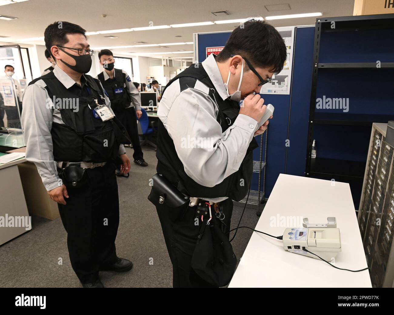 Employees of a security company take a breathalyzer test with an