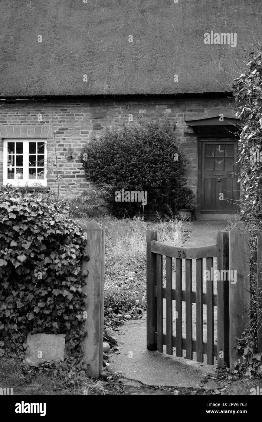 Puerta abierta monocroma y camino del jardín a la casa de campo Inglés durante enero Foto de stock