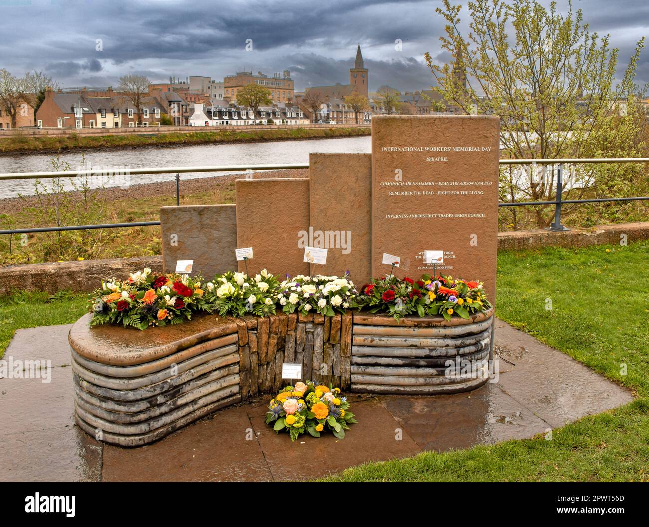 Inverness Escocia junto a las losas de piedra del río Ness y los homenajes florales para el Día Internacional de los Trabajadores 28th de abril Foto de stock