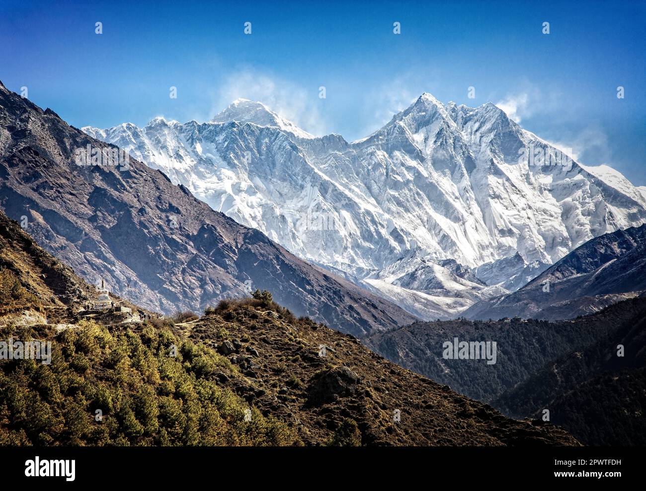 El sendero al campamento base del Everest pasa por una estuppa mientras el viento soplaba el monte. El Everest (izquierda) se eleva sobre una cresta en el Parque Nacional Sagarmatha, Nepal. Foto de stock