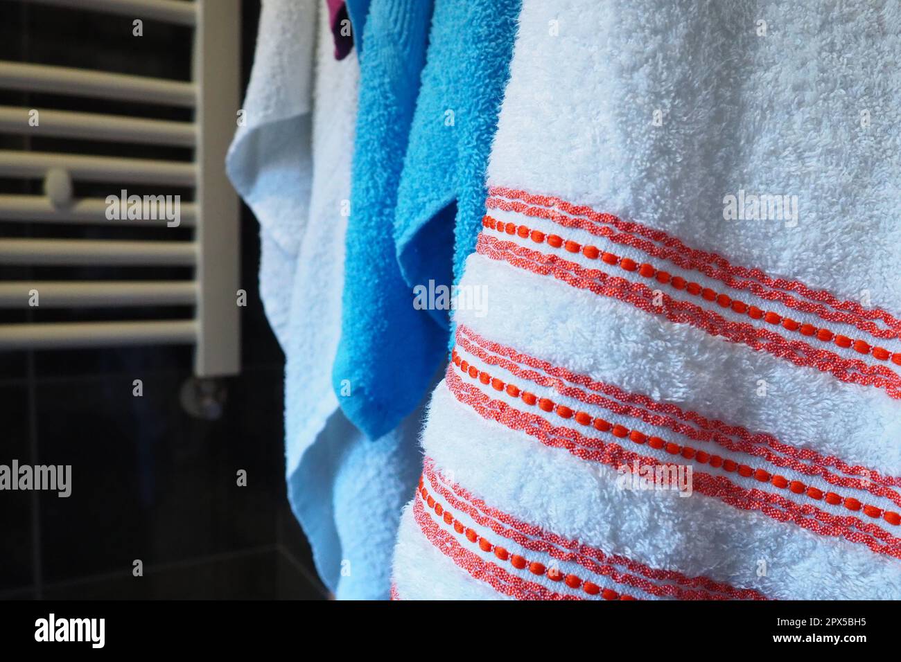 Rojo de albornoz y toalla blanca en la pared arriba del radiador en chapa  blanca baño con toallas en estanterías de metacrilato Fotografía de stock -  Alamy