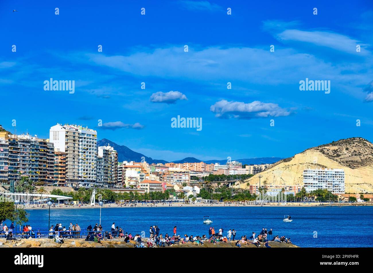 Ocean Race, Alicante, España: La gente de la costa ve el famoso evento anual. El paisaje urbano o el horizonte está en el fondo. Foto de stock