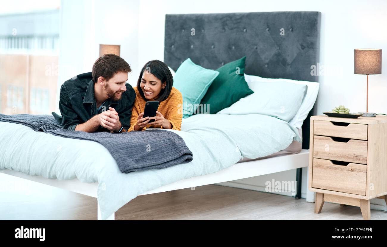 Cuando la química es real puedes sentir la conexión. una joven pareja  usando un smartphone juntos en su cama en casa Fotografía de stock - Alamy