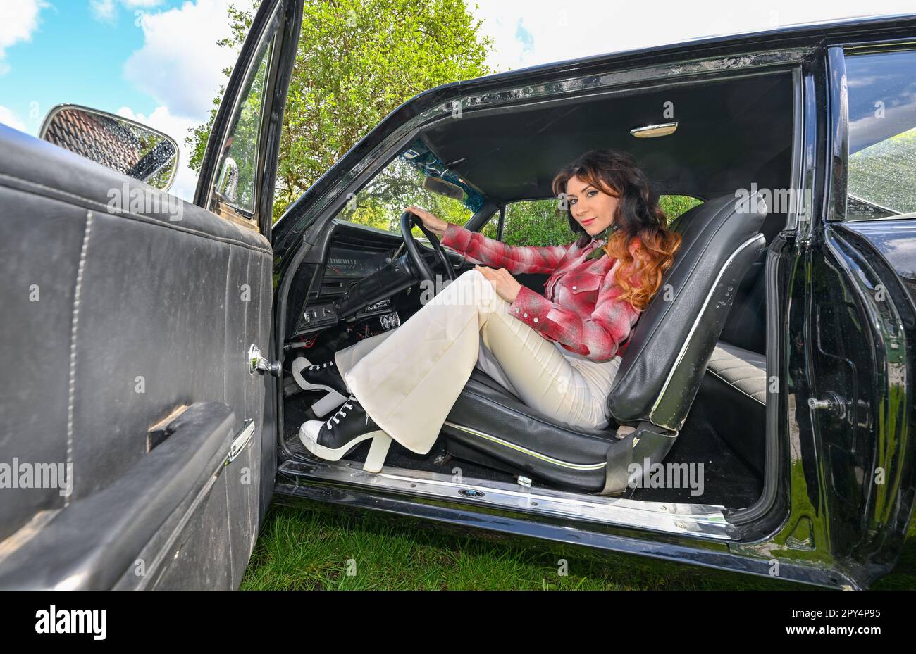 Schwedt, Alemania. 26th de abril de 2023. Leokadia Hateville, aerógrafo y artista de graffiti, se sienta en su Chevrolet Nova estadounidense de los años 69. En su tiempo libre, Leokadia Hateville tiene gasolina en su sangre y su pie en el acelerador, pero no en los modernos y lujosos autos deportivos. Ella compite en carreras con coches viejos que ya ni siquiera se hacen hoy en día - como una de las pocas mujeres pilotos hasta la fecha. Crédito: Patrick Pleul/dpa/Alamy Live News Foto de stock