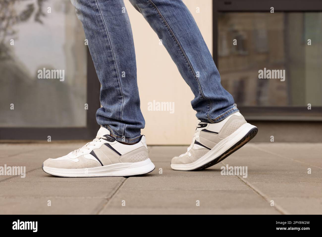 Hombre en jeans y zapatillas de deporte caminando en la calle de la ciudad,  primer plano Fotografía de stock - Alamy