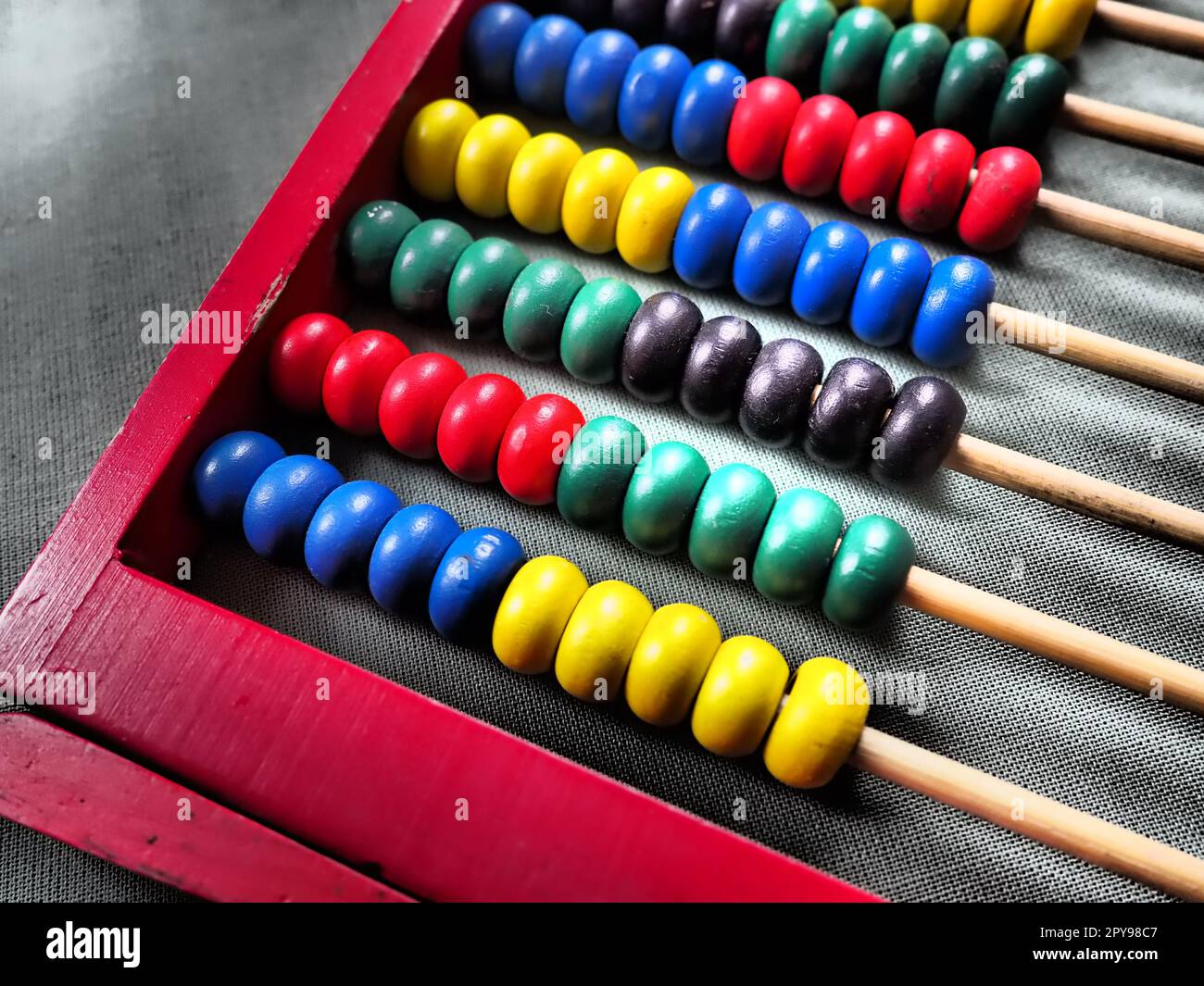 Concepto de educación - ábaco con muchas cuentas de colores. Rojo, azul, verde, negro, detalles amarillos en el ábaco. Ejercicios matemáticos. Programa escolar Foto de stock