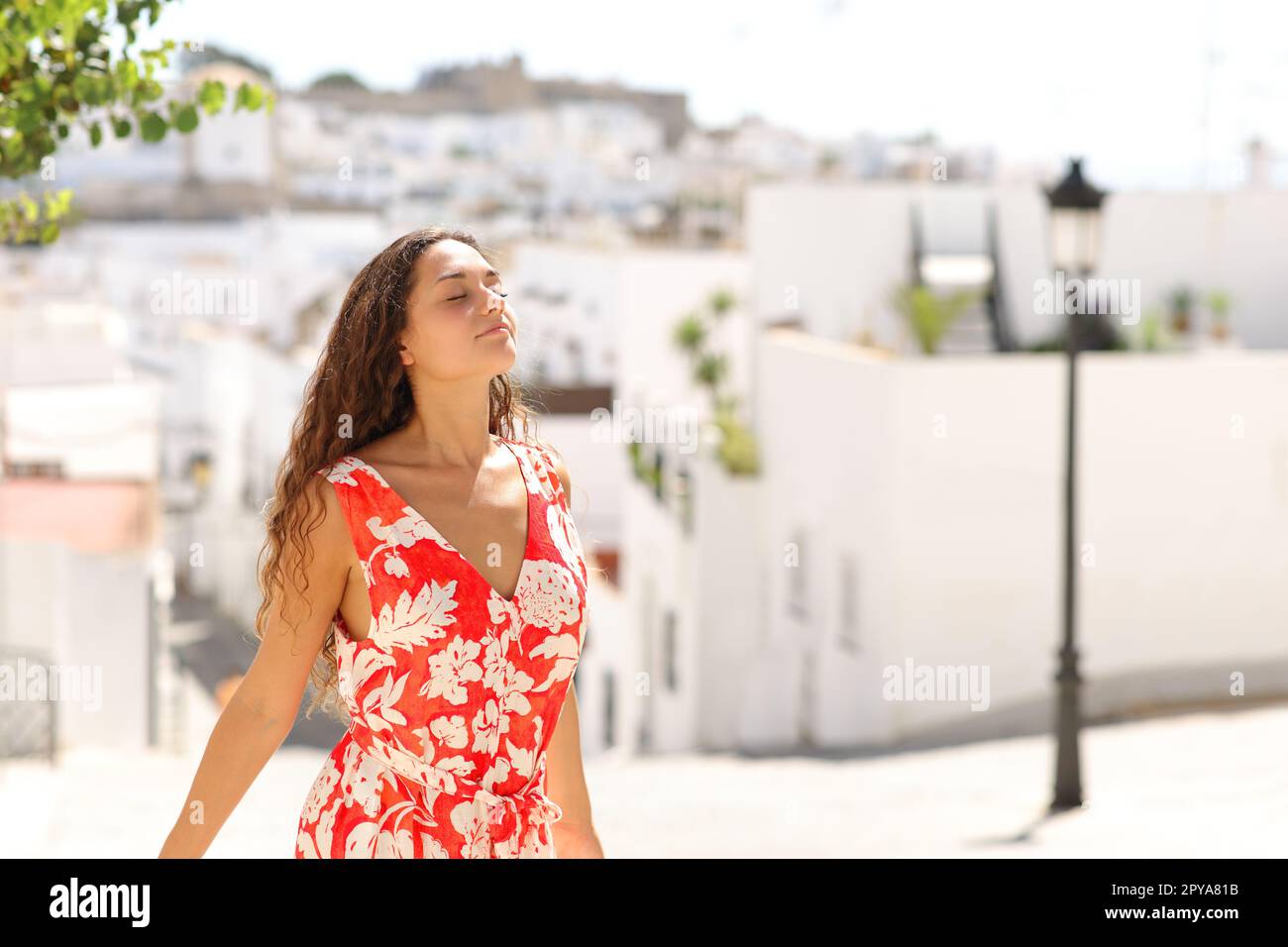 Turista en rojo respirando aire fresco en una ciudad blanca Foto de stock