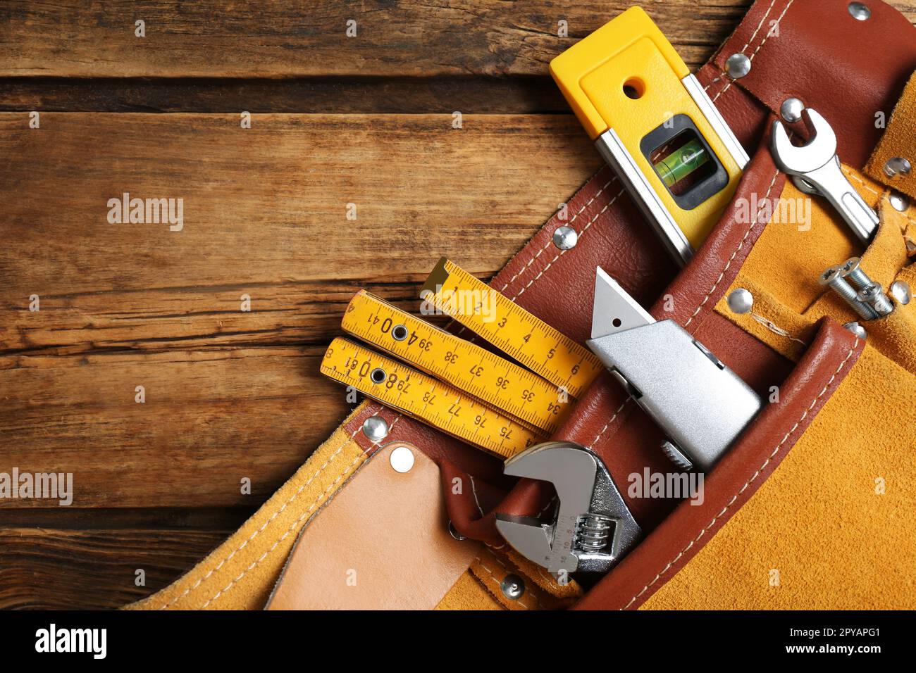 Cinturón con cuchillo utilitario y diferentes herramientas en la mesa de  madera, vista superior. Espacio para texto Fotografía de stock - Alamy