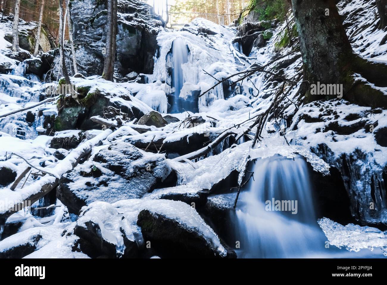 cascadas congeladas con hielo y nieve en el bosque Foto de stock