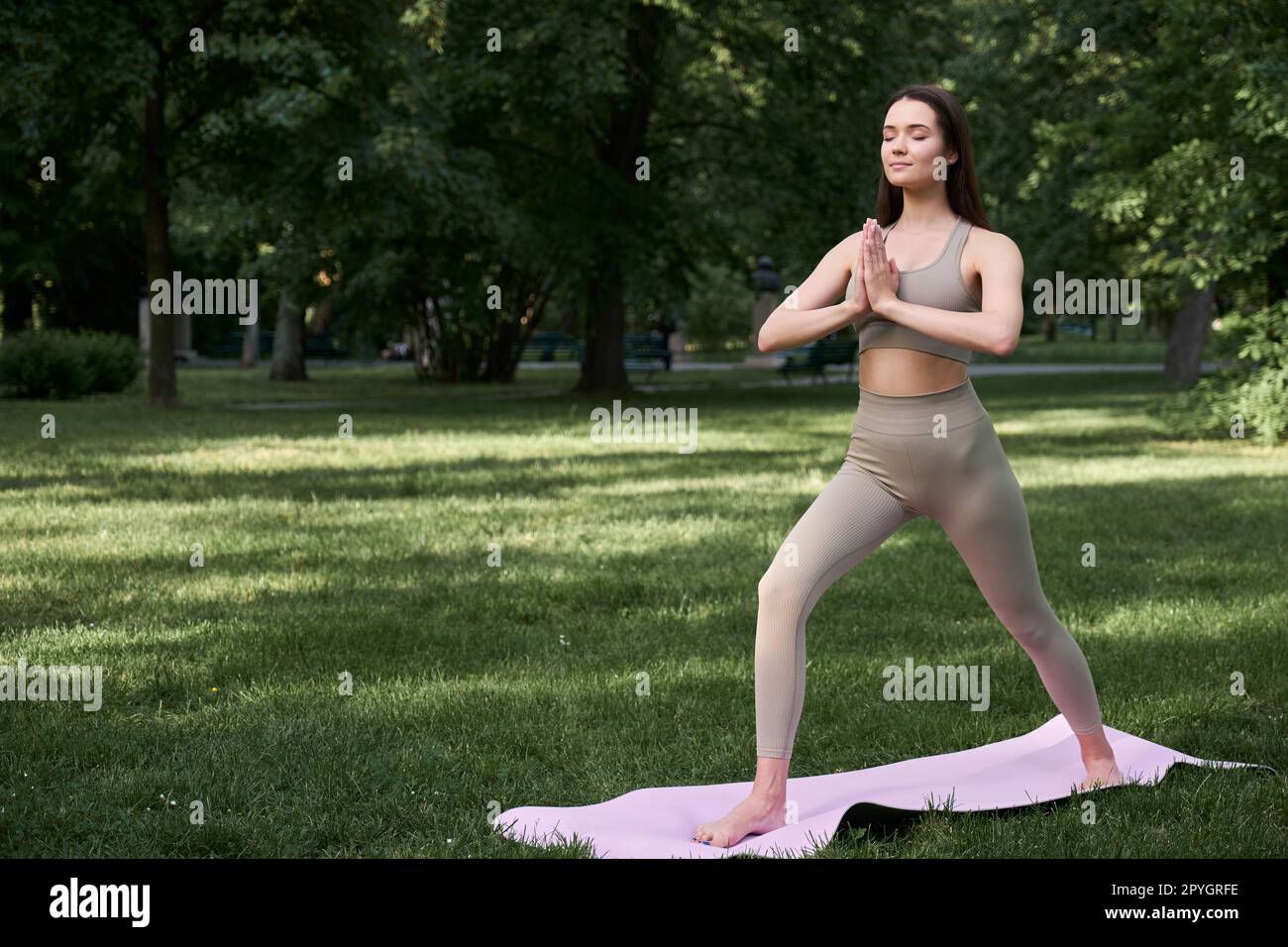 Joven atractiva mujer morena en ejercicios de ropa deportiva con gomas de  fitness en el parque al amanecer.