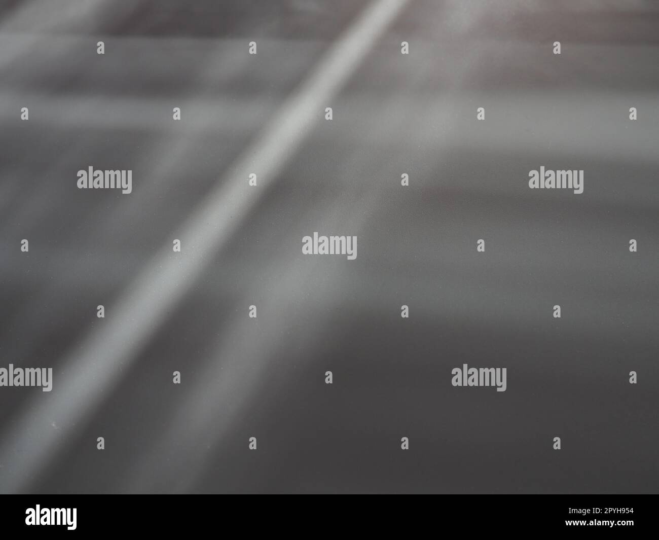 Rayos de iluminación sobre superficie gris. Los rayos abstractos de luz y la lente brillan sobre un fondo gris. Rayas de luz verticales, horizontales y diagonales Foto de stock