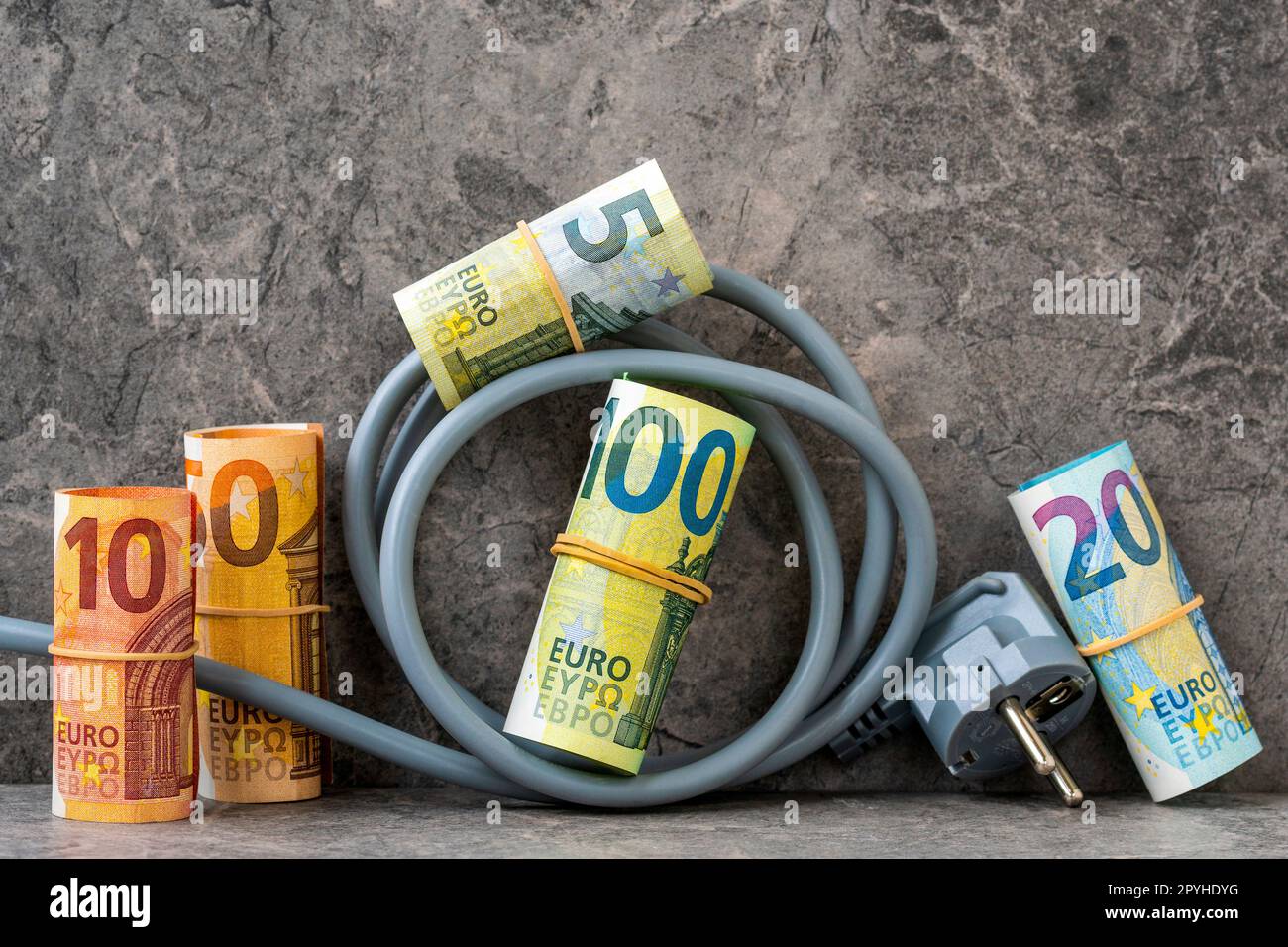 Cable eléctrico con rollos de dinero en euros Foto de stock
