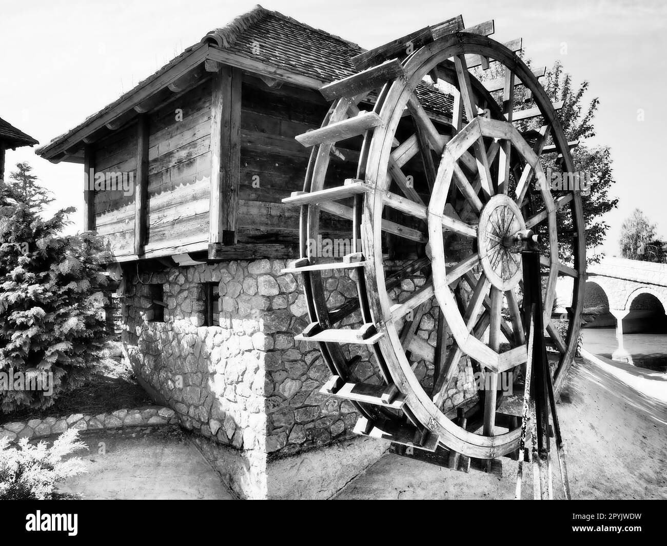 Molino de agua de madera. Una estructura hidráulica que utiliza la energía hidroeléctrica de una rueda de agua. Trabajo útil mediante un tren de engranajes Foto de stock