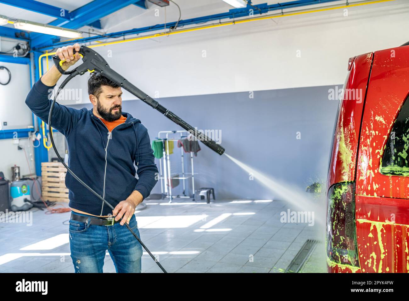 lavar los coches con la presión de agua de un pulverizador en una lavadora de mano Foto de stock