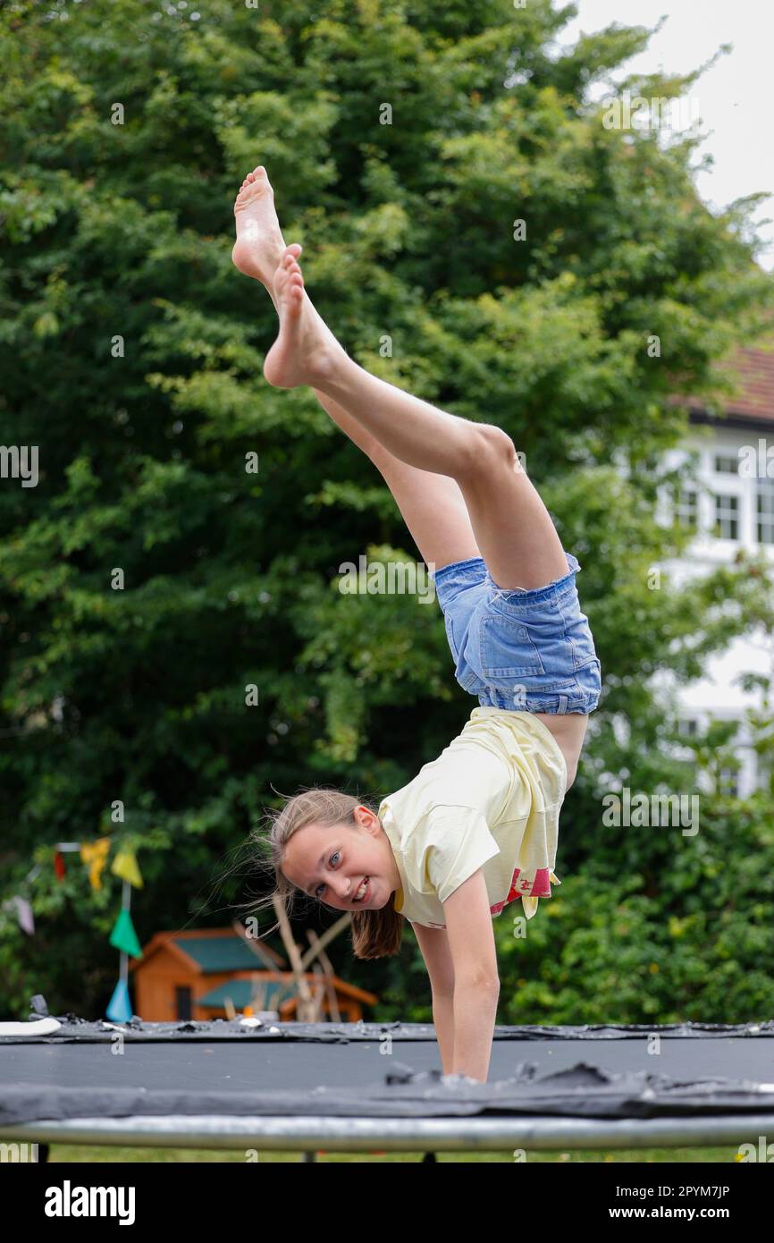 Chica joven jugando en un trampolín, Little Waltham, Essex, Inglaterra Foto de stock