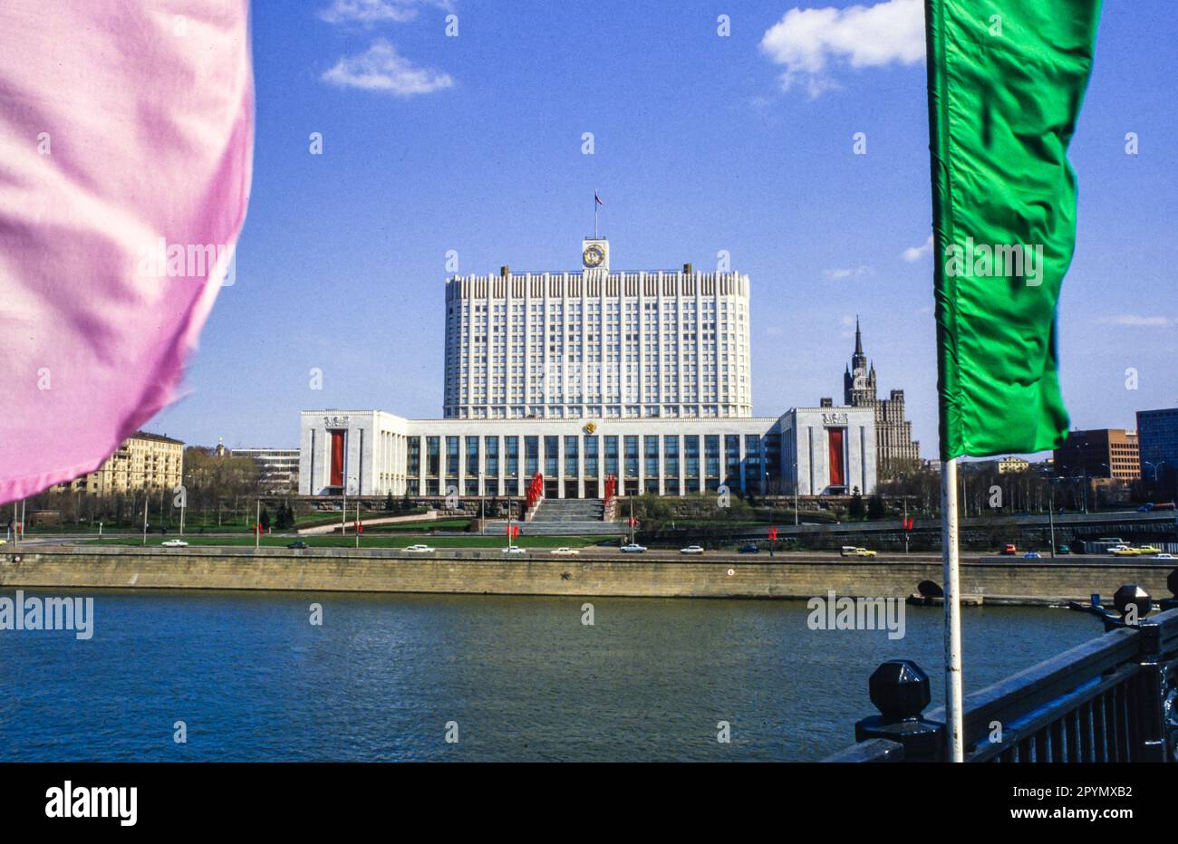 1988: La Casa de los Soviets de Rusia, justo antes del Primero de Mayo de 1988. El edificio se hizo más conocido como la Casa Blanca Rusa después del golpe de agosto de 1991 y fue gravemente dañado por el incendio de tanques en 1993 durante la crisis constitucional rusa, pero desde entonces ha sido restaurado. El edificio barroco de estilo 'pastel de bodas' en el fondo es el edificio de la Plaza Kudrinskaya, una de las llamadas 'Siete Hermanas' encargado por Joseph Stalin como parte de un plan para modernizar Moscú inmediatamente después de la Segunda Guerra Mundial Otra de las Siete Hermanas, el Hotel Ukraina, está frente a la Casa Blanca al otro lado del río Moskva. Foto de stock