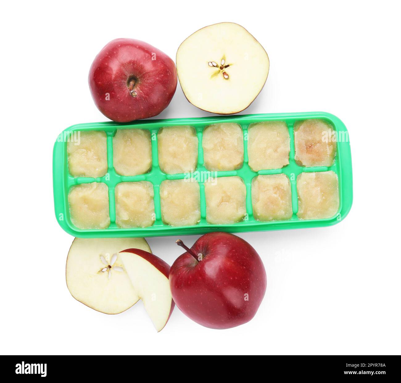 Puré de manzana en bandeja de cubitos de hielo e ingredientes sobre fondo blanco, vista superior. Listo para congelar Foto de stock