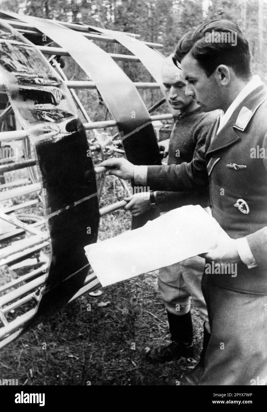 Soldados de la Luftwaffe alemana frente a un tambor de secado en el que se estiran las imágenes de un avión de reconocimiento. Antes del ataque a la Unión Soviética, las posiciones de las tropas soviéticas eran intensamente reconocedoras. [traducción automatizada] Foto de stock