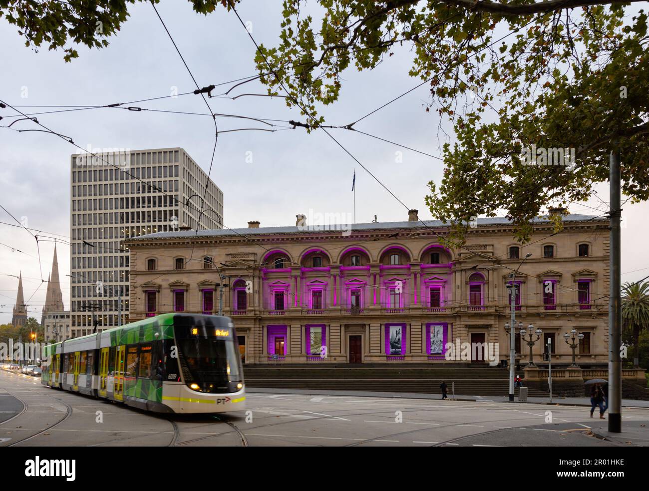 Melbourne CBD Sábado, mayo. 6, 2023. Un tranvía pasa por la Casa del Parlamento victoriano iluminado en púrpura antes de la coronación del rey Carlos III.Corleve / Alamy Live News Foto de stock