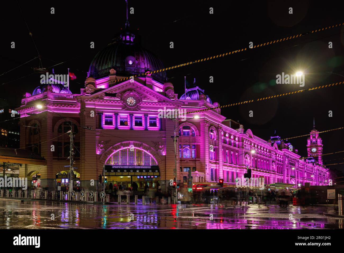 Melbourne CBD Sábado, mayo. 6, 2023. Estación de la calle Flinders en una noche lluviosa iluminada en púrpura para conmemorar la coronación del rey Carlos III Corleve/Alamy Noticias en vivo Foto de stock