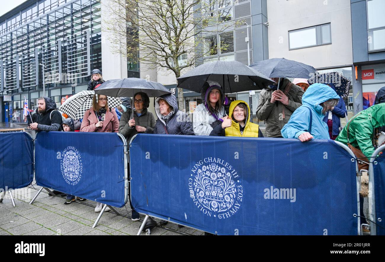 Brighton UK 6 de mayo de 2023 - Las multitudes hacen cola bajo la lluvia para ver la coronación del rey Carlos III en una gran pantalla en la Plaza Jubileo de Brighton hoy: Crédito Simon Dack / Alamy Live News Foto de stock