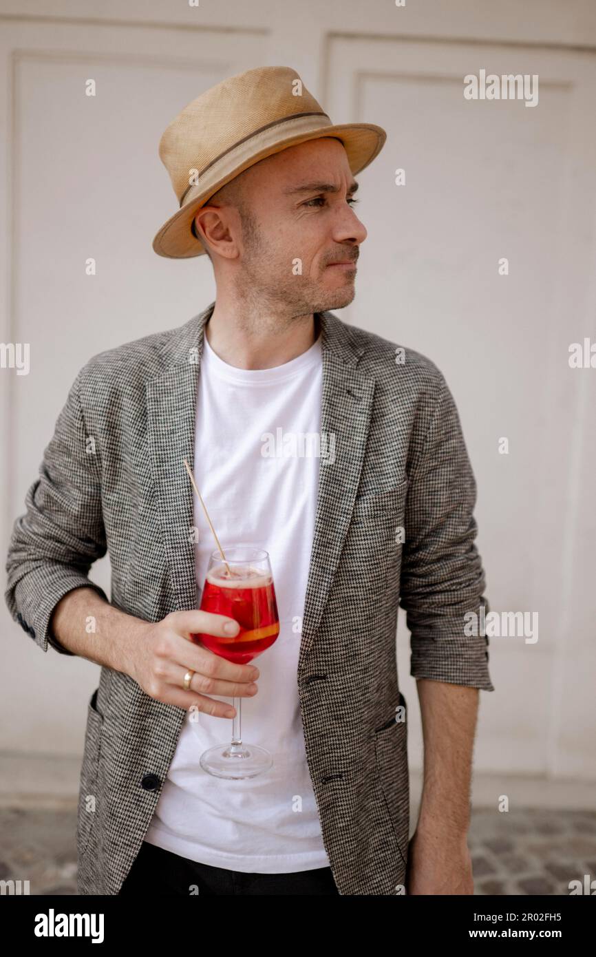 Hombre con un sombrero y una copa de Aperol Spritz Foto de stock